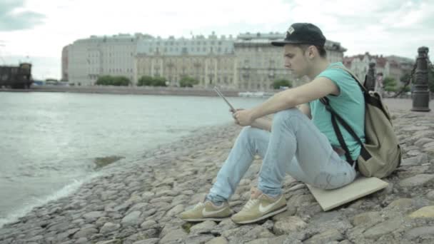 Człowiek za pomocą tabletu pc nad jeziorem - Materiał filmowy, wideo