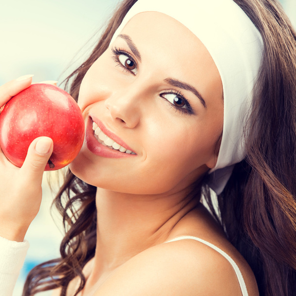 Woman with apple, at fitness gym - Fotoğraf, Görsel
