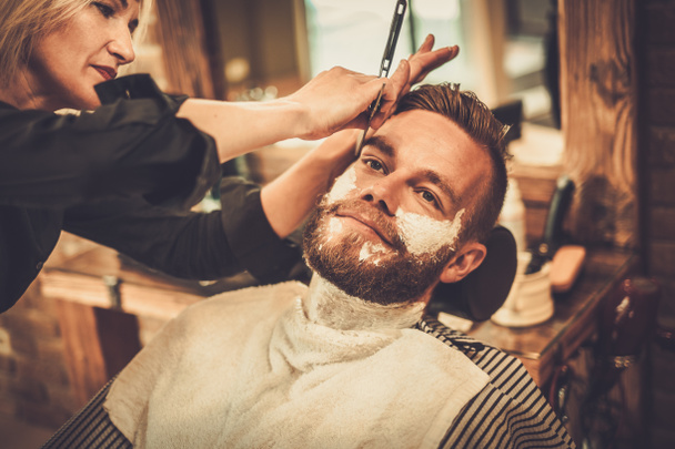 Cliente durante rasatura di barba in negozio di barbiere - Foto, immagini