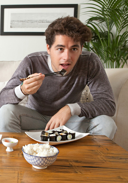 Hombre comiendo sushi japonés
 - Foto, imagen