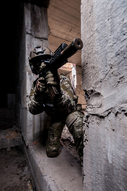 Soldato dell'esercito russo spara una mitragliatrice dal nascondiglio in un edificio abbandonato
 - Foto, immagini