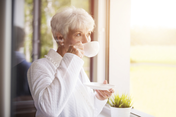 mature woman drinking coffee - Fotó, kép