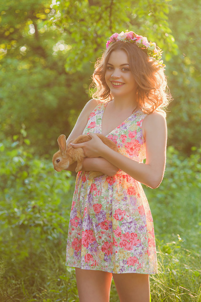 Beautiful girl with a rabbit in the hands - Foto, imagen