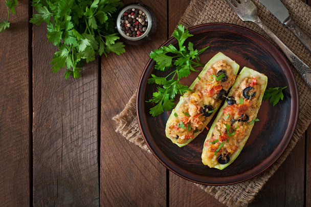 Stuffed zucchini with chicken, tomatoes and olives with cheese crust - Photo, Image