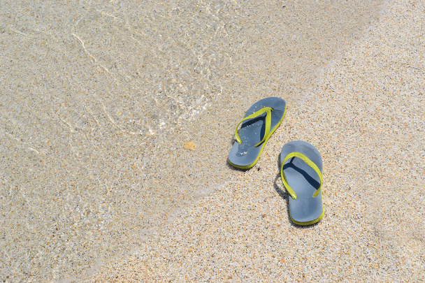 Tongs sur une plage de sable
  - Photo, image