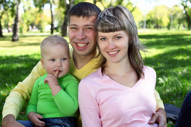 Familia joven con un niño en el parque de verano
 - Foto, Imagen