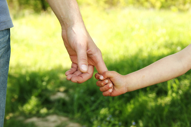 Eltern halten die Hand eines Kindes - Foto, Bild