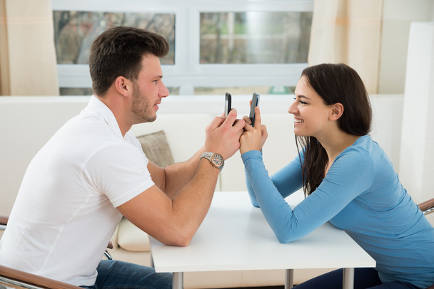 Glückliches Paar beim SMS-Schreiben auf dem Handy - Foto, Bild