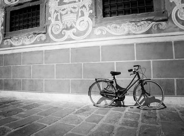red bike leaning against a wall in black and white - Photo, Image