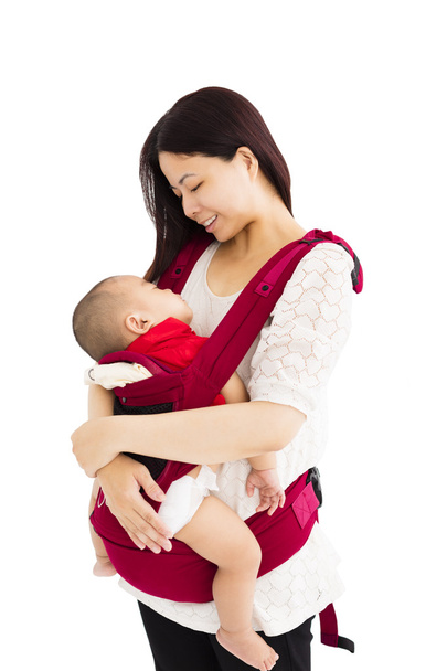bir bebek tutan bir bebek taşıyıcı anne - Fotoğraf, Görsel