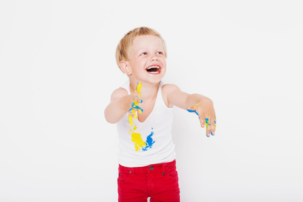 Boy with hands painted in colorful paints ready to make hand prints. School. Preschool. Education. Creativity. Studio portrait over white background - Foto, immagini