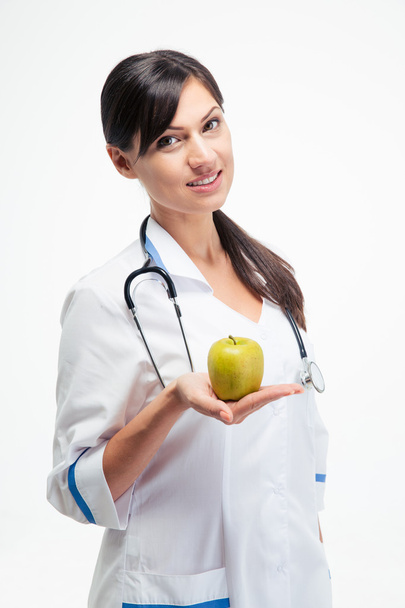 Smiling female doctor holding apple  - Фото, зображення