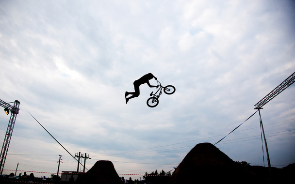 Силует чоловіка, який стрибає з велосипедом bmx проти заходу сонця
  - Фото, зображення
