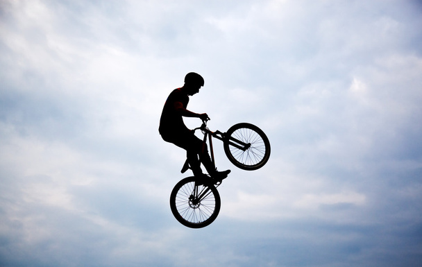 Silhouette of a man doing a jump with a bmx bike against sunset  - Photo, Image