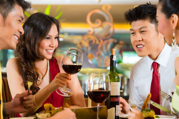 Kiinalaiset parit paahtavat viiniä ravintolassa
 - Valokuva, kuva