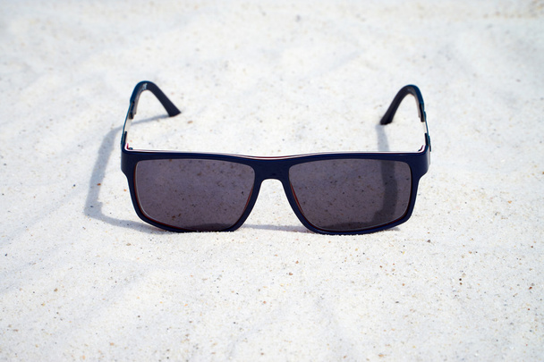 Óculos escuros na areia
 - Foto, Imagem