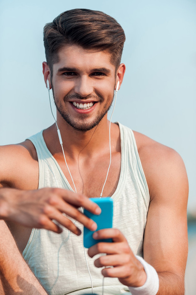 man in headphones holding smart phone - Photo, image