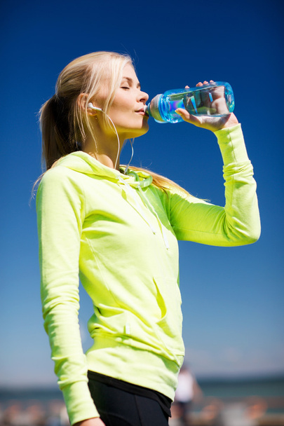 woman drinking water after doing sports outdoors - Foto, imagen