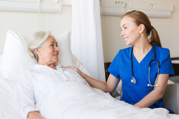 doctor or nurse visiting senior woman at hospital - Valokuva, kuva