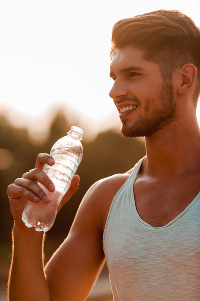 muscular man holding  bottle - Foto, afbeelding