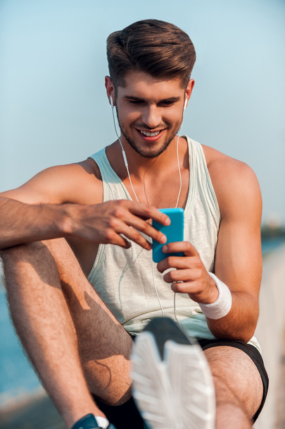 man in headphones looking at MP3 player - Photo, image