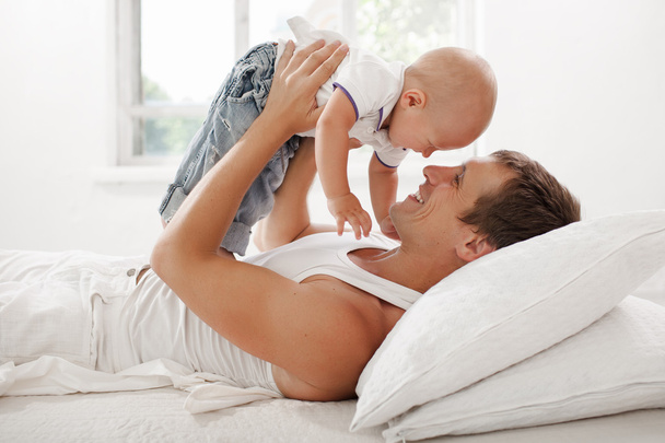 young father with his nine months old som on the bed at home - Foto, immagini
