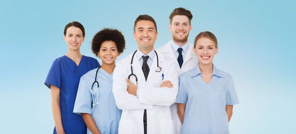 group of happy doctors over blue background - Foto, imagen