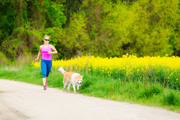 Mujer corriendo en el parque de verano con perro
 - Foto, imagen