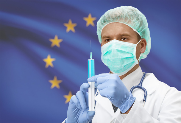 Orvos-val fecskendő kéz és a zászló a háttérben sorozat - az Európai Unió - Eu - Fotó, kép