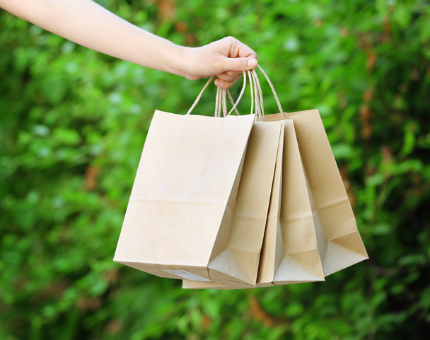 Female hand holding shopping bags outdoors - Fotoğraf, Görsel