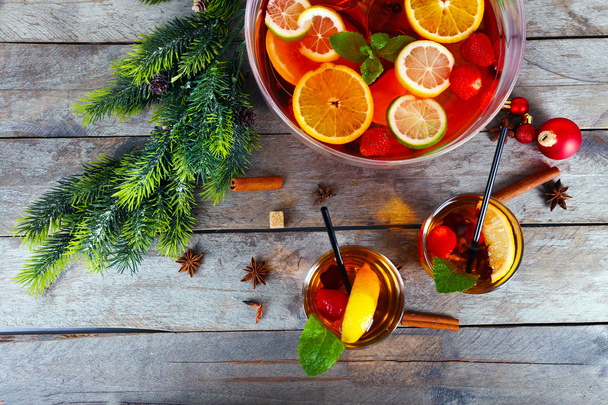 Sangria in bowl and glasses with Christmas decoration on wooden table close up - Fotó, kép