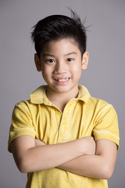 asiático chico es poco sonrisa y buscando cámara
 - Foto, imagen