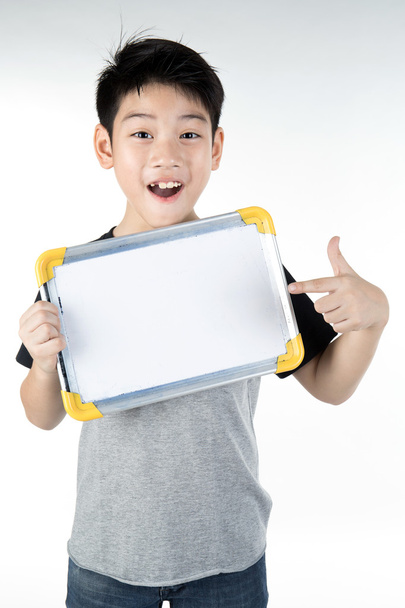 Ázsiai fiú üres fehér tábla és látszó cam kis mosoly - Fotó, kép