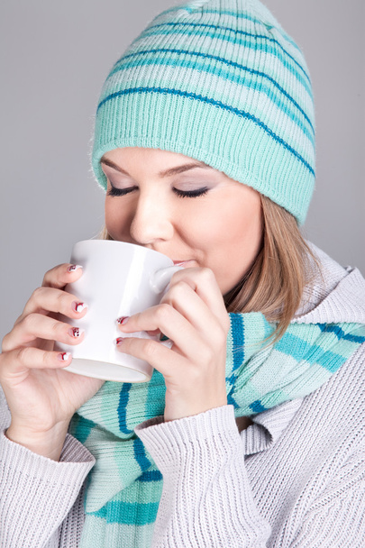 Smiling winter woman holding hot tea - Fotó, kép