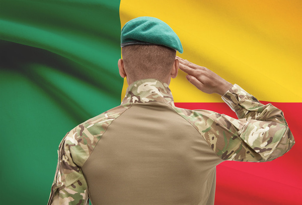 Piel oscura soldado con bandera sobre fondo - Benín - Foto, imagen