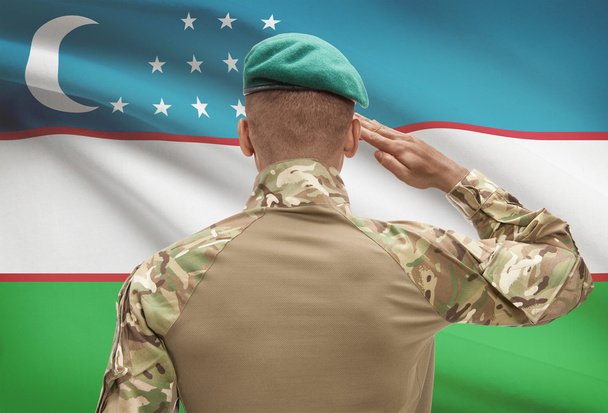 Soldat de peau foncée avec drapeau sur fond - Ouzbékistan - Photo, image
