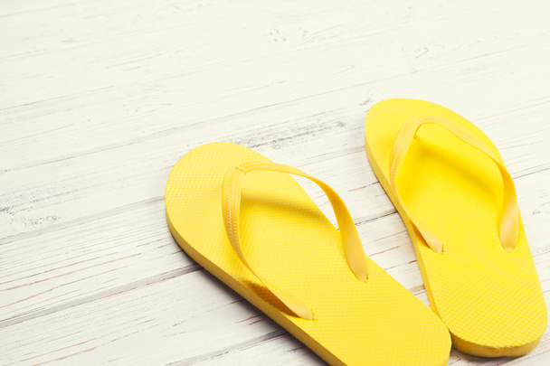 Yellow flip-flops on wooden background - Photo, Image