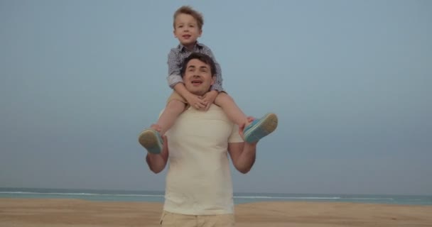 Jego świetna zabawa jeździć na ramionach ojców - Materiał filmowy, wideo