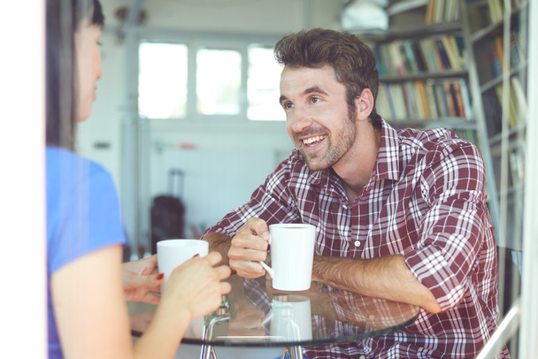 couple sitting inside apartment and drinking coffee - Photo, image