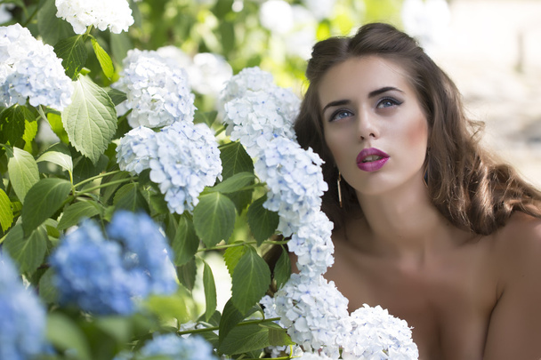 Portret atrakcyjną kobietę i niebieski kwiaty - Zdjęcie, obraz