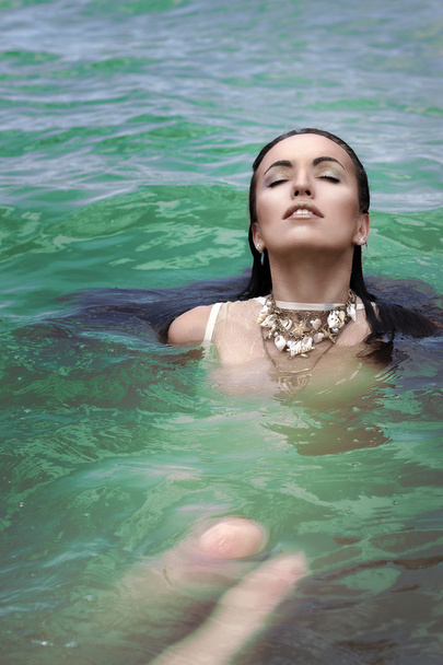 Beautiful girl brunette in green lake swimming in clothes - Valokuva, kuva