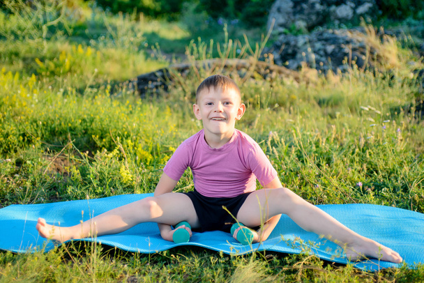 Criança sorridente levantando pesos enquanto divide as pernas
 - Foto, Imagem