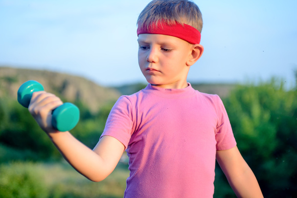 Close up Thoughtful Young Boy Lifting Dumbbell - Fotografie, Obrázek