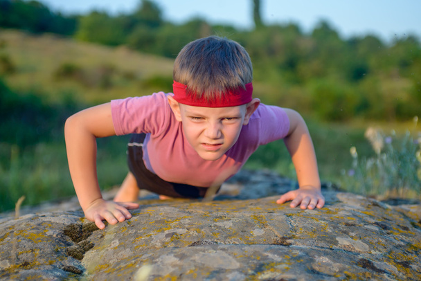 Strong Male Kid Doing Push up on Big Rock - Photo, Image