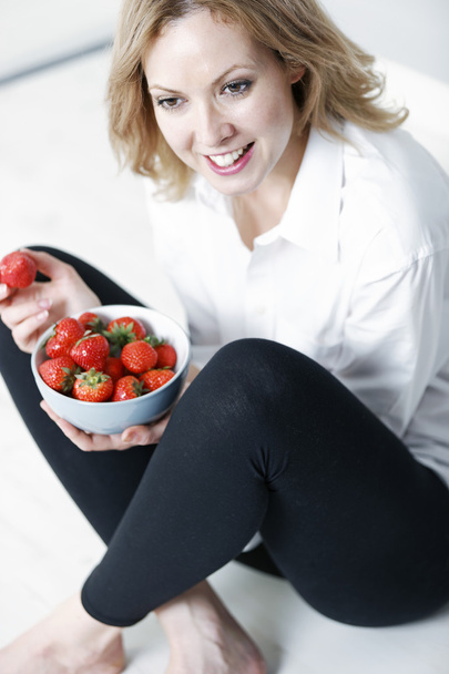 新鮮なイチゴを食べる女性 - 写真・画像