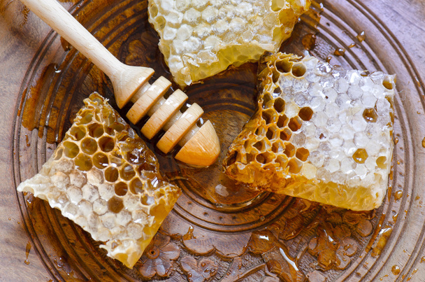 Honingraat met honing Beer op vintage houten plaat - Foto, afbeelding