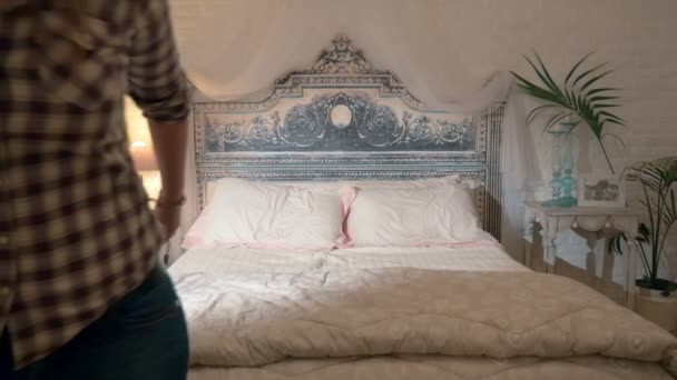 ベッドに飛び乗る幸せな若いカップル - 映像、動画