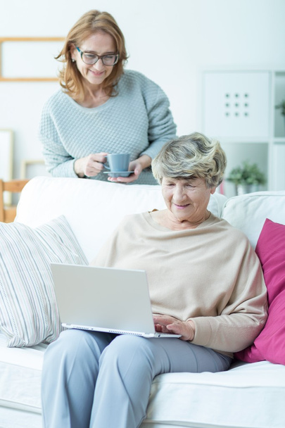 Vanhempi nainen kannettavan tietokoneen kanssa
 - Valokuva, kuva