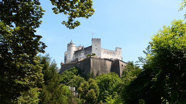 Fortaleza de Hohensalzburg enmarcada por árboles en Salzburgo
 - Foto, imagen
