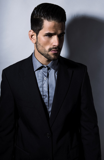 schöner junger Mann im Anzug auf grauem Hintergrund. Geschäftsmann - Foto, Bild